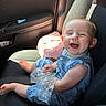 Olive joined the competition — help win amazing prizes! baby, child, car_seat, blue_romper, plastic_bag, smiling, closed_eyes, sunlight, pink_blanket, car_interior, seat, happy, infant, cute, sitting, hands, feet, joy, portrait, person