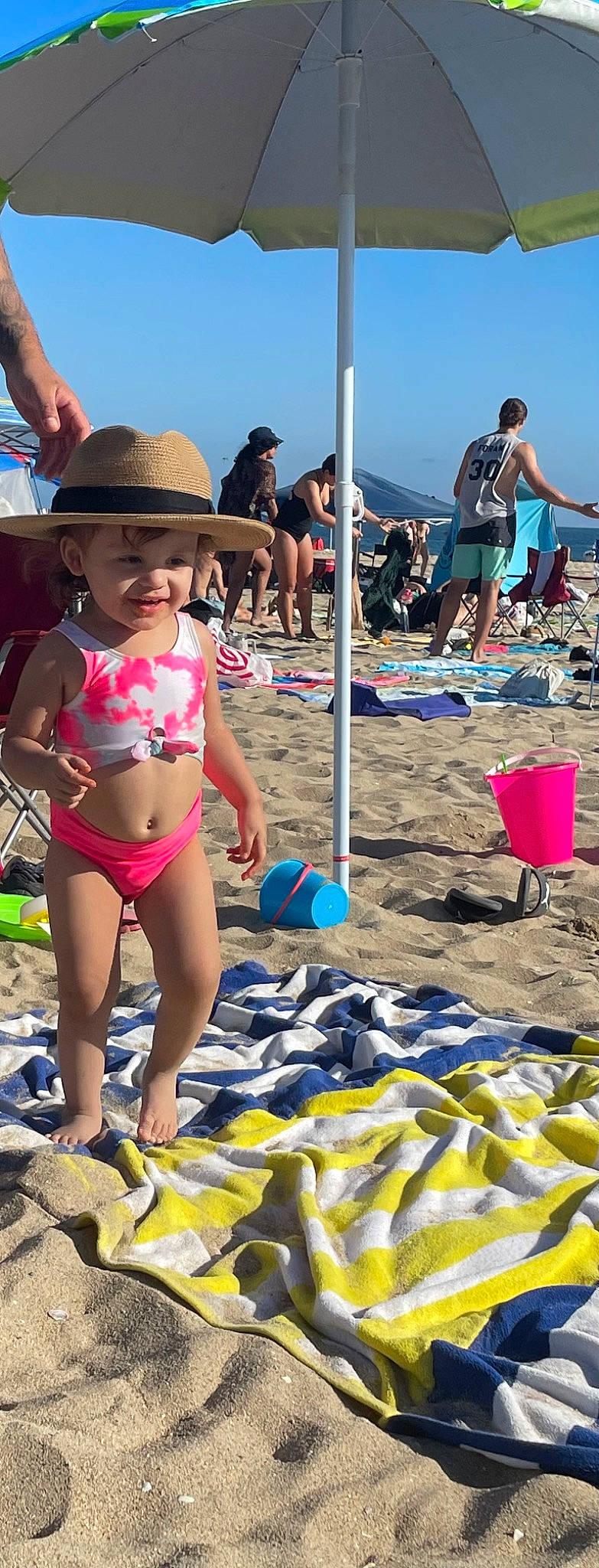 Daisy is registered to the contest to win money with this photo: beach, body_of_water, brassiere, eyewear, fun, hat, headgear, headwear, leisure, natural_environment, people_on_beach, person, recreation, sand, shorts, sky, sun_hat, swimsuit_top, swimwear, thigh