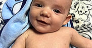 Kashtyn joined the competition — help win amazing prizes! baby, infant, child, portrait, smiling, face, eyes, lying_down, blanket, blue_blanket, bed, bedding, patterned_background, indoors, close_up, bare_chest, happy, cute, photograph, head