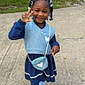 Aartaviah is registered to the contest to win money with this photo: child, girl, smiling, outdoor, sidewalk, street, neighborhood, portrait, fashion, blue_outfit, dress, sweater_vest, purse, heart, hair_bows, braids, peace_sign, shoes, socks, mailbox