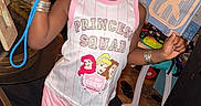 Aartaviah is registered to the contest to win money with this photo: child, girl, toddler, portrait, indoors, smiling, pouting, sunglasses, pink_hat, cat_ears, princess, dress, shorts, bracelets, toy_fan, toy, fashion, sitting, living_room, playful