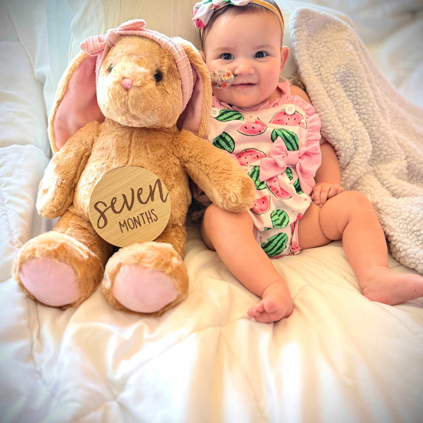 Sendaya is registered to the contest to win money with this photo: baby, child, plush_toy, bunny, bed, blanket, headband, pink, watermelon_print, smile, cute, infant, soft_toy, comfort, cozy, indoors, portrait, sitting, happy, person