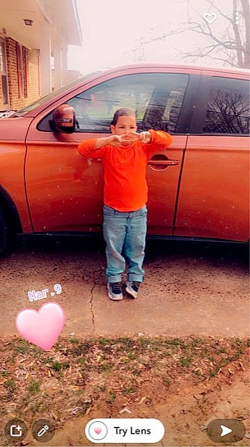 Jared is registered to the contest to win money with this photo: alloy_wheel, automotive_design, automotive_exterior, automotive_lighting, automotive_tire, bumper, car, fender, hood, jeans, land_vehicle, mammal, motor_vehicle, natural_environment, person, red, rim, tire, vehicle, vehicle_door