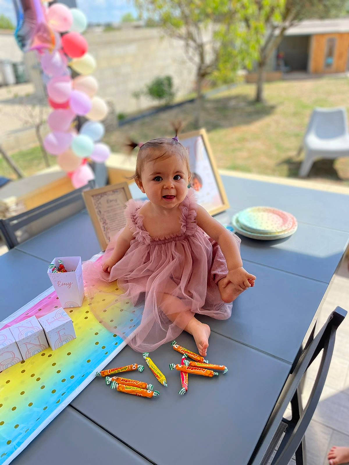 Emy participe au concours pour gagner de l'argent avec cette photo : baby, balloon, chair, child, dress, event, fun, happy, leisure, person, pink, plant, play, recreation, sitting, smile, summer, table, toddler, toy