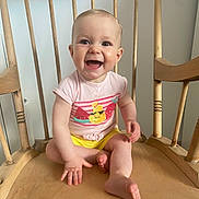 Albane a rejoint le concours — aidez-le/la à gagner de superbes lots ! baby, child, smiling, happy, sitting, wooden_chair, indoor, tshirt, yellow_shorts, barefoot, cute, person, infant, face, small_hand, legs, wood, furniture, bright_clothing, joyful