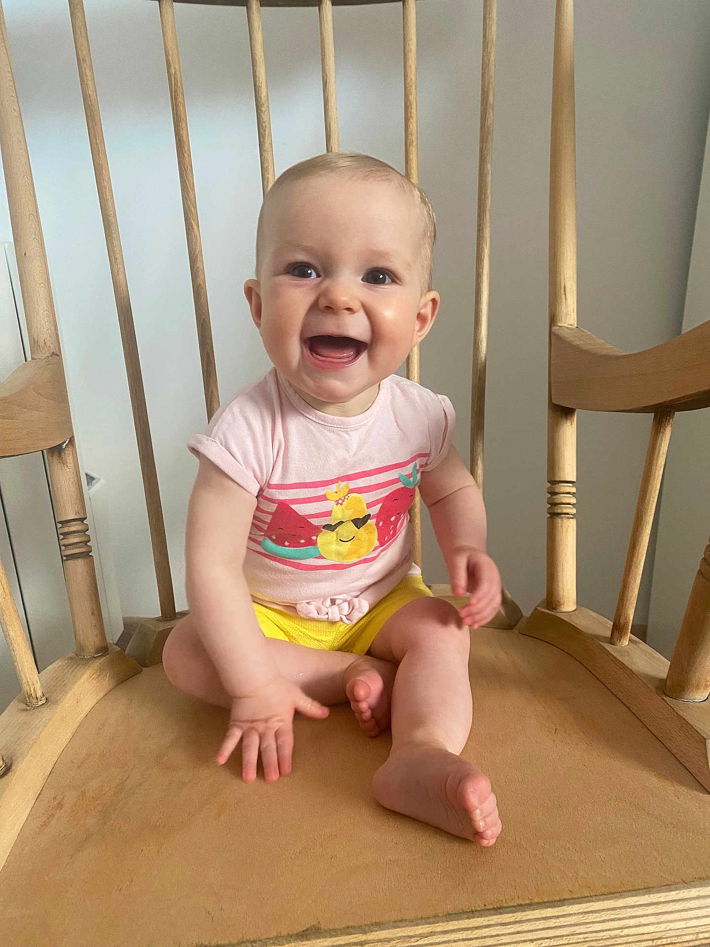 Albane a rejoint le concours — aidez-le/la à gagner de superbes lots ! baby, child, smiling, happy, sitting, wooden_chair, indoor, tshirt, yellow_shorts, barefoot, cute, person, infant, face, small_hand, legs, wood, furniture, bright_clothing, joyful