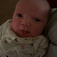 Azariah is registered to the contest to win money with this photo: baby, infant, face, tongue, onesie, clothing, cute, expression, closeup, portrait, person, newborn, sleepwear, indoors, soft_light, child, skin, head, cheeks, mischievous