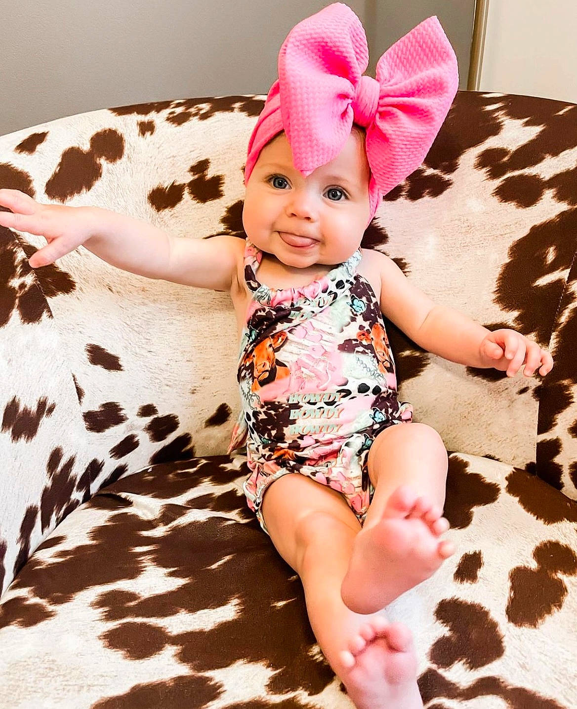 Charley is registered to the contest to win money with this photo: arm, baby, baby_toddler_clothing, costume_hat, dress, finger, foot, fun, happy, headwear, human_leg, magenta, neck, pattern, person, pink, sitting, skin, sleeve, smile