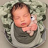 Freddy is registered to the contest to win money with this photo: newborn, baby, sleeping, teddy_bear, blanket, swaddled, portrait, close_up, peaceful, cozy, infant, face, hands, closed_eyes, brown_hair, soft_lighting, basket, textile, nursery, cuddling