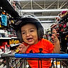 Steve joined the competition — help win amazing prizes! child, toddler, helmet, orange_shirt, shopping_cart, walmart, store, aisle, shelves, products, smiling, happy, indoor, retail, baby, clothing, person, cute, fun, shopping