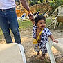 Yetxiel is registered to the contest to win money with this photo: toddler, child, adult, holding_hands, outdoor, sunlight, smiling, curly_hair, sippy_cup, casual_clothing, nature, trees, lawn_chair, footwear, barefoot, stone_wall, greenery, daylight, playful, happy