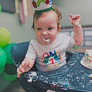 Mateo joined the competition — help win amazing prizes! baby, birthday, cake, celebration, child, colorful, crown, face, first_birthday, food, frosting, hands, happy, high_chair, indoor, messy, party, person, shirt, smile