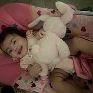 Valentyna is registered to the contest to win money with this photo: baby, baby_seat, bunny, child, clothing, cute, fabric, happy, hearts, indoor, infant, pattern, person, pink, playful, seat, smiling, stars, stuffed_toy, toy