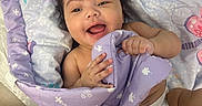 Valentyna is registered to the contest to win money with this photo: baby, blanket, bow, child, cozy, cute, diaper, face, hand, happy, indoors, infant, joyful, lying_down, person, playful, purple, skin, smiling, soft