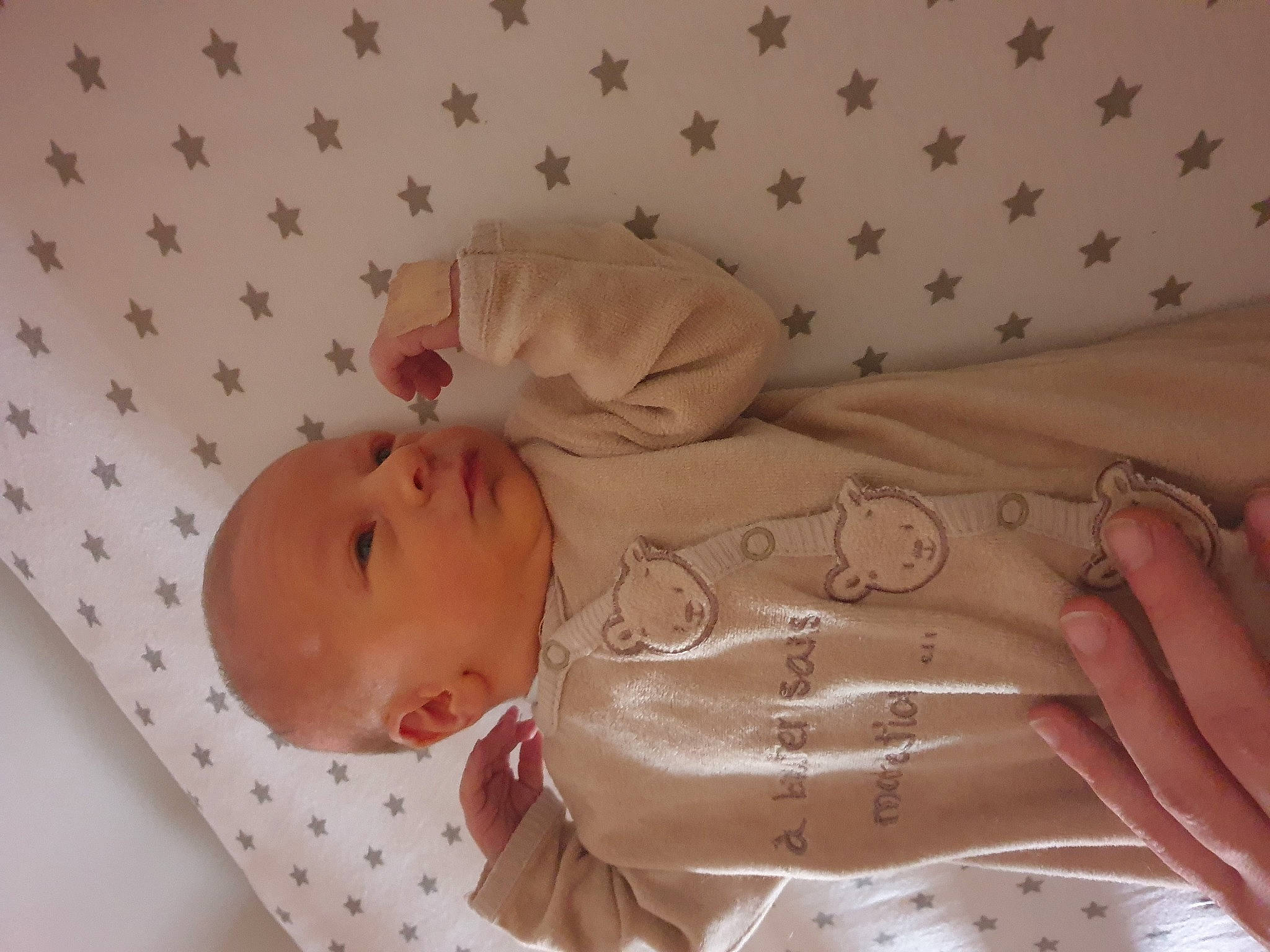 Adam participe au concours pour gagner de l'argent avec cette photo : arm, baby, baby_products, baby_toddler_clothing, child, comfort, dress, finger, gesture, hand, human_body, linens, pattern, peach, person, pink, room, skin, sleeve, toddler