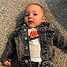 baby, infant, child, portrait, lying_down, carpet, denim_jacket, jeans, clothing, nike, fashion, casual, indoor, floor, face, blue_eyes, looking_at_camera, serious_expression, photography, full_body