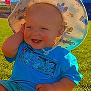 Sawyer joined the competition — help win amazing prizes! baby, child, smiling, hat, blue_shirt, outdoor, grass, sunlight, portrait, happy, sitting, face, person, summer, cute, infant, clothing, nature, daylight, headwear