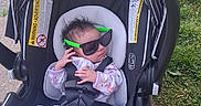 Infinitee joined the competition — help win amazing prizes! baby, infant, car_seat, sunglasses, green, outdoor, grass, sidewalk, clothing, onesie, safety_harness, cute, person, head, hair, hand, footwear, fashion, child, accessory