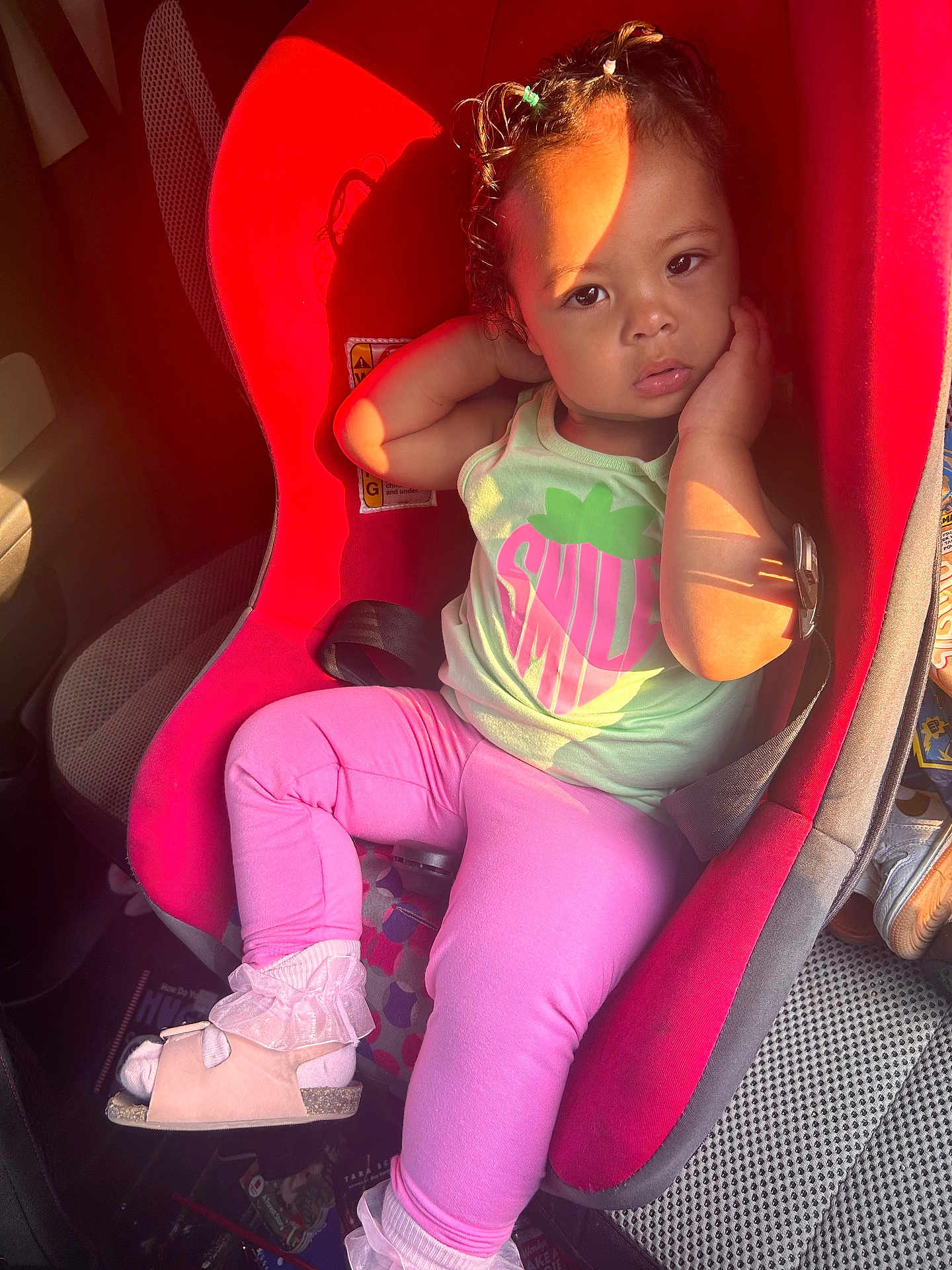 Amiri joined the competition — help win amazing prizes! toddler, child, car_seat, red, pink_leggings, mint_green_top, smile_print, sunlight, car_interior, seatbelt, hair_ties, relaxed, portrait, cute, young_child, casual_clothing, sitting, indoors, daylight, footwear