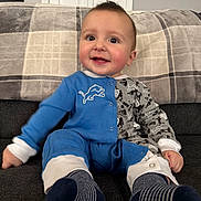 Roman joined the competition — help win amazing prizes! baby, big_eyes, button_snaps, child, clothing, couch, cozy, fabric_texture, footwear, happy, indoor, infant, onesie, plaid_blanket, portrait, rosy_cheeks, short_hair, sitting, smiling, socks