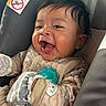 baby, infant, smiling, pajamas, mittens, car_seat, formula_bottle, happy, closeup, face, child, cute, indoor, person, infant_formula, warning_label, expression, clothing, comfort, seat