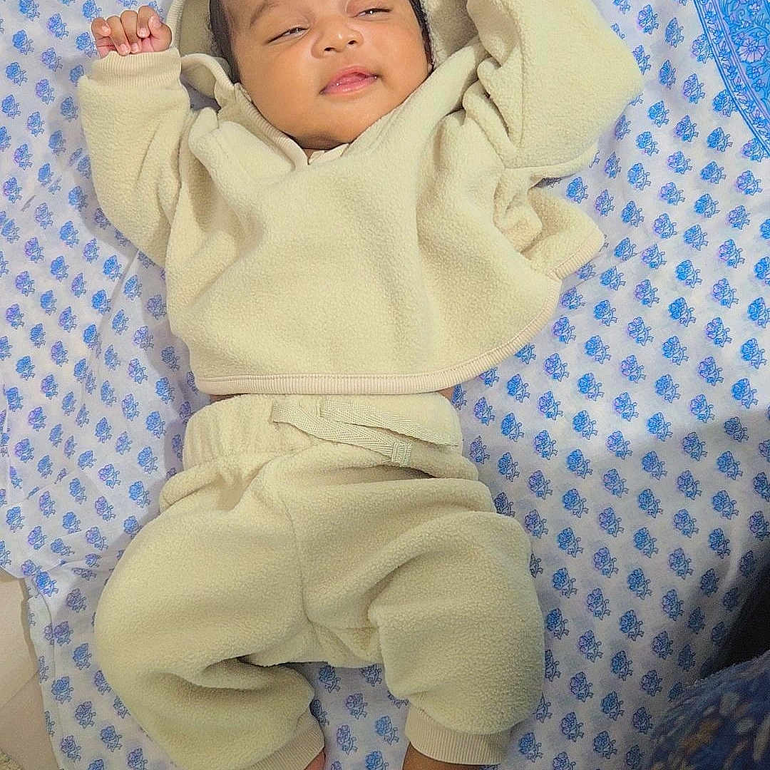 Aviraj joined the competition — help win amazing prizes! anklet, arms_up, baby, blanket, blue, child, cute, fabric, footwear_none, indoors, infant, lying_down, patterned, peaceful, portrait, relaxed, sleepwear, smiling, soft_clothing, white