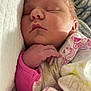 newborn, baby, sleeping, hand, face, blanket, patterned_blanket, pink_sleeve, closeup, infant, resting, peaceful, soft_light, portrait, indoor, skin, cute, child, cozy, young