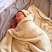 Hilona a rejoint le concours — aidez-le/la à gagner de superbes lots ! baby, bed, blanket, comfort, cozy, cushion, fabric, face, headwear, indoors, infant, newborn, peaceful, person, portrait, rest, sleeping, soft, warm, wrapped
