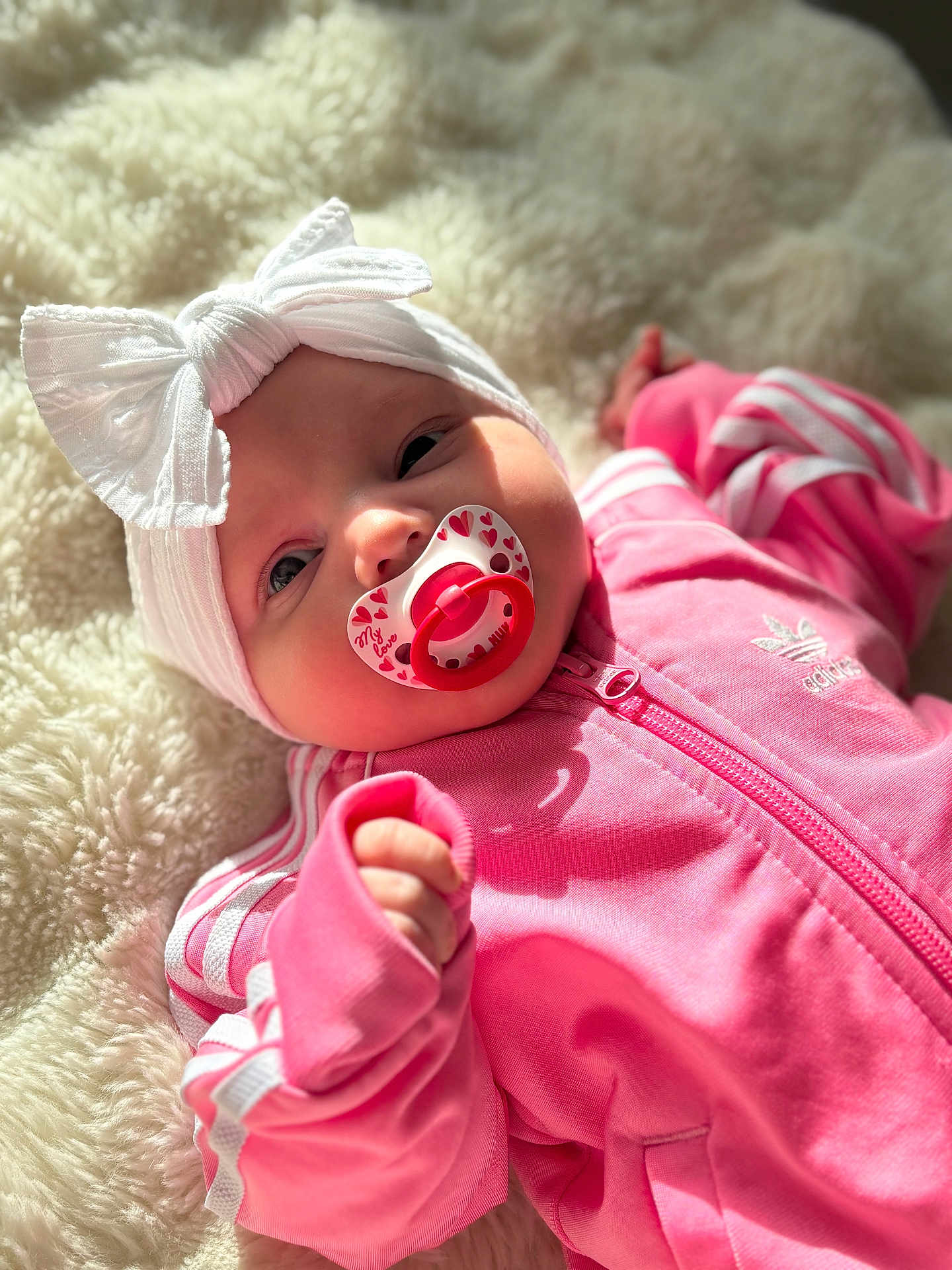 Zeyna participe au concours pour gagner de l'argent avec cette photo : baby, pacifier, headband, pink_clothing, white_bow, blanket, infant, adorable, closeup, face, soft_light, child, cozy, indoor, cute, portrait, young_child, fashion, sleepwear, relaxed