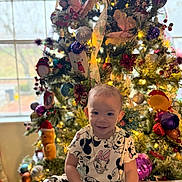 Sofia joined the competition — help win amazing prizes! child, toddler, smiling, christmas_tree, holiday, indoor, festive, lights, ornaments, decorations, clothing, boots, table, window, happy, person, celebration, seasonal, cute, joyful