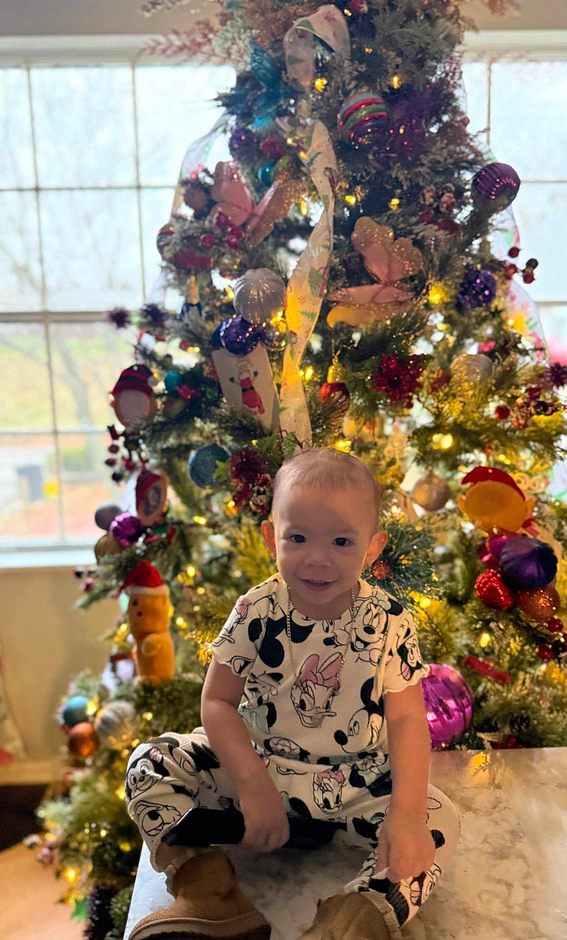 Sofia joined the competition — help win amazing prizes! child, toddler, smiling, christmas_tree, holiday, indoor, festive, lights, ornaments, decorations, clothing, boots, table, window, happy, person, celebration, seasonal, cute, joyful