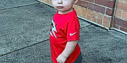 Zaydon joined the competition — help win amazing prizes! toddler, child, boy, red_shirt, nike, shorts, socks, bear_socks, sidewalk, brick_wall, outdoor, curious, standing, casual_clothing, young_child, portrait, concrete, urban, daylight, cute