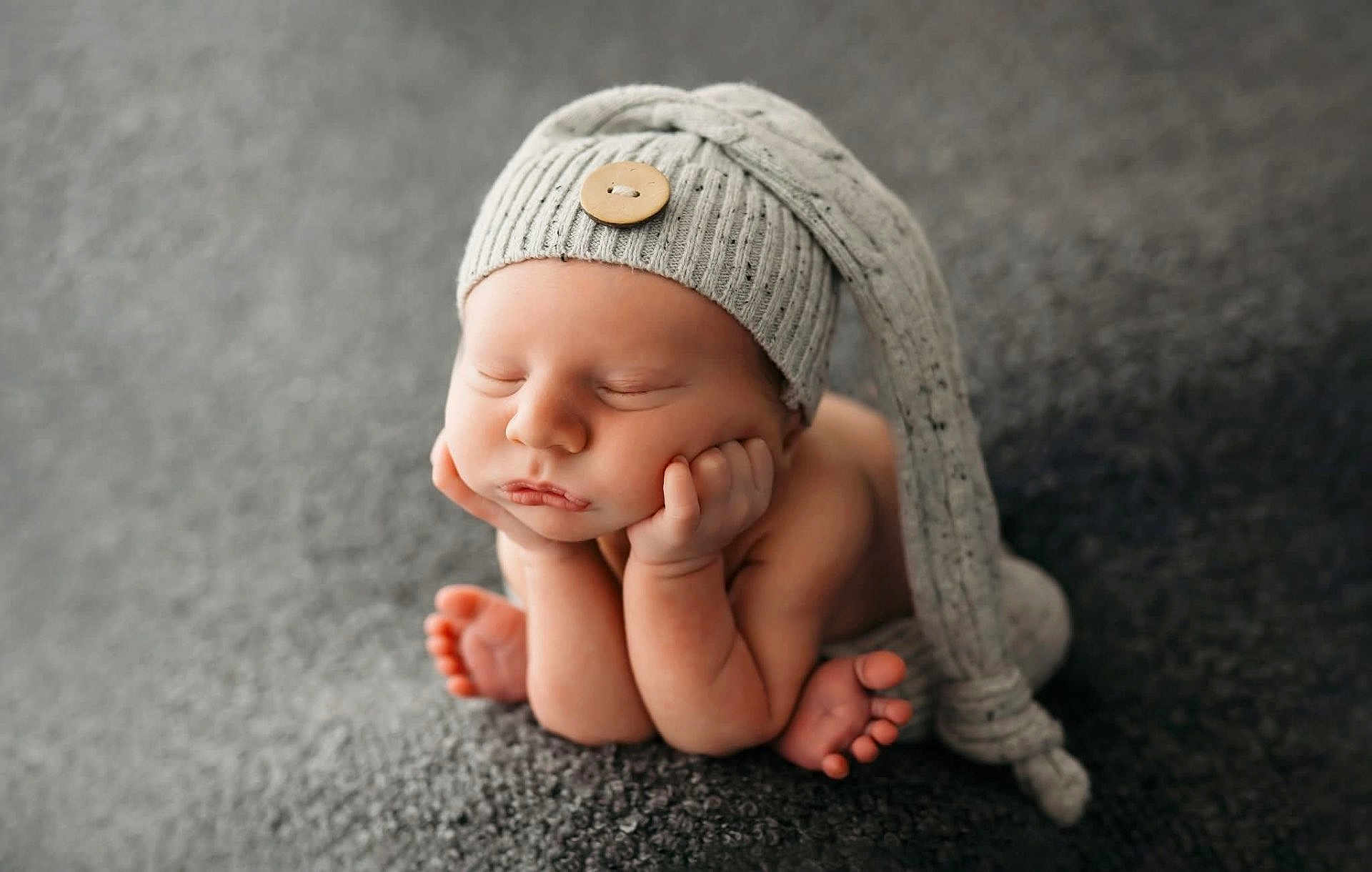 Raiden is registered to the contest to win money with this photo: newborn, baby, sleeping, hat, knit_hat, hands, feet, cute, portrait, infant, soft_texture, gray_background, peaceful, closeup, child, studio, cozy, warm, resting, tiny