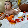 baby, infant, pumpkin, autumn_leaves, blanket, fall, cute, child, decor, orange, white, skin, expression, lying_down, indoors, seasonal, holiday, celebration, curious, soft