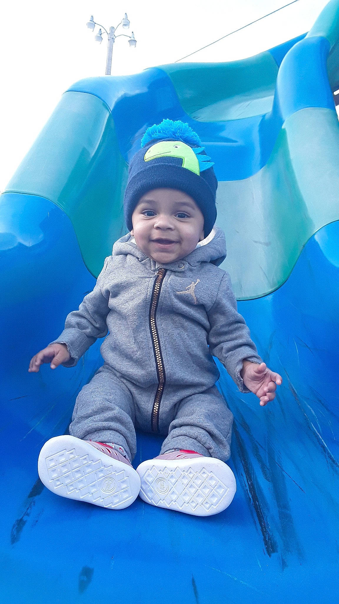 D'Andre is registered to the contest to win money with this photo: baby, blue, child, fun, games, happy, leisure, outdoor_play_equipment, person, play, recreation, smile, toddler, vacation