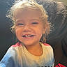 Victoria joined the competition — help win amazing prizes! child, toddler, smiling, portrait, curly_hair, blonde_hair, blue_eyes, gap_tooth, sitting, couch, indoor, home, sunlight, warm_lighting, shirt, freedom_text, happy, face, closeup, casual