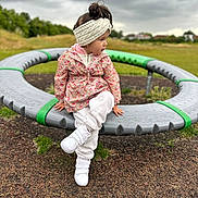 Antonia joined the competition — help win amazing prizes! child, girl, playground, outdoor, cloudy_sky, grass, jacket, headband, white_shoes, sitting, crossed_legs, play_equipment, park, casual_clothing, nature, young_child, daytime, thoughtful, headwear, footwear