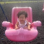 Desiree Gayle is registered to the contest to win money with this photo: toddler, child, swing, playground, pink_swing, smiling, happy, outdoor, sunlight, grass, trees, baby, summer, fun, play, seat, park, cute, person, joy