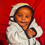 Kingston joined the competition — help win amazing prizes! baby, child, hooded_robe, blue_clothing, smiling, dimples, face, hands, red_background, cozy, cute, infant, portrait, warmth, soft_lighting, indoors, person, young_child, happy, apparel