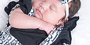 Jaliyah joined the competition — help win amazing prizes! baby, sleeping, infant, headband, bow, black_clothing, white_background, soft_texture, cute, peaceful, portrait, newborn, child, adorable, hand, face, closed_eyes, fluffy, fashion, resting