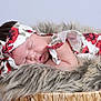 baby, sleeping, headband, floral_pattern, fur_blanket, basket, newborn, peaceful, soft_texture, infant, cute, resting, portrait, indoor, child, adorable, closeup, skin, clothing, cozy