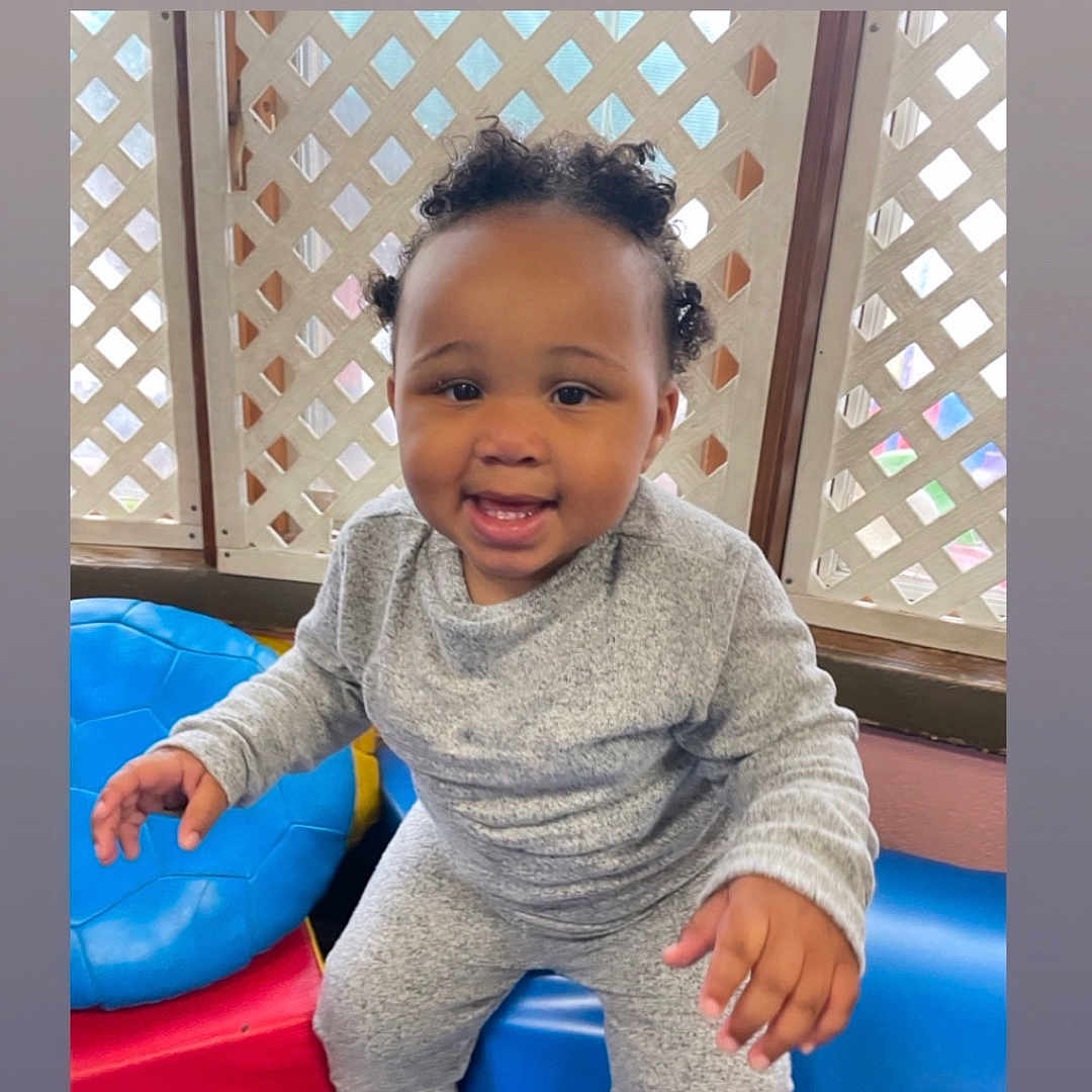 Kalanii is registered to the contest to win money with this photo: baby, bodypart, clothing, face, finger, footwear, happy, head, indoors, mouth, outdoors, pants, person, photography, playarea, portrait, shoe, sitting, smile, teeth