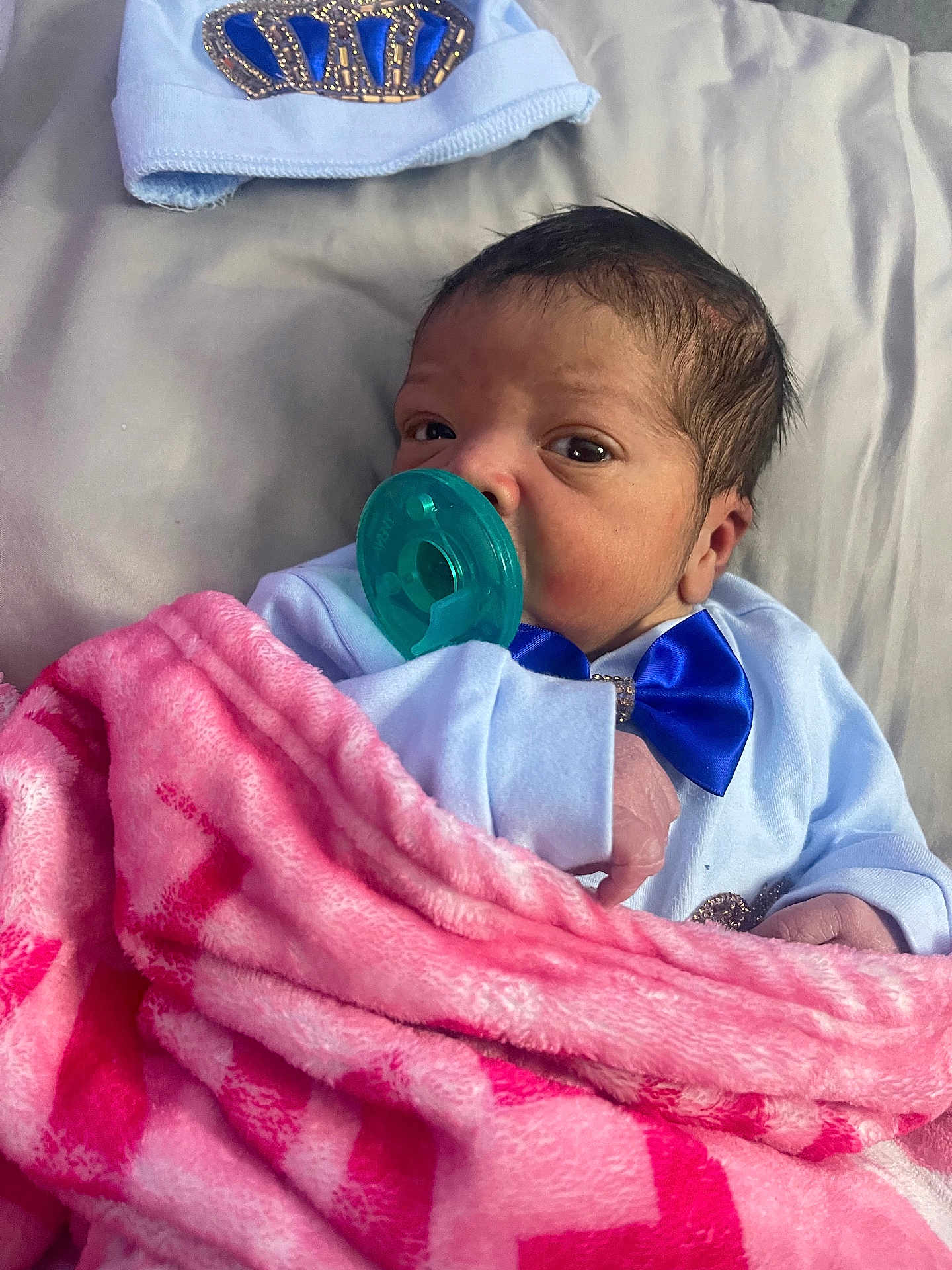 Orion joined the competition — help win amazing prizes! baby, newborn, infant, green_pacifier, pink_blanket, blue_bow, beanie_hat, bedding, portrait, close_up, clothing, hand, hair, face, eyes_open, cozy, bed, skin, hospital_blanket, adorable