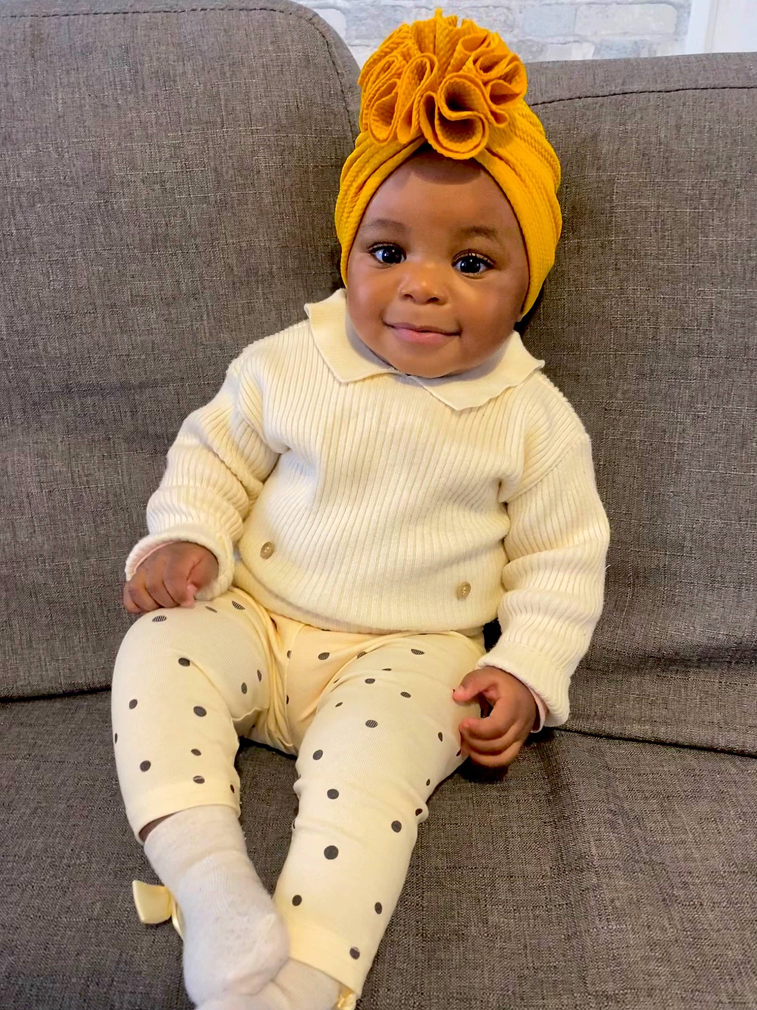Lola a rejoint le concours — aidez-le/la à gagner de superbes lots ! baby, baby_toddler_clothing, cap, child, comfort, costume_hat, couch, fashion_accessory, happy, headgear, joy, knee, linens, outerwear, pattern, person, sitting, sleeve, smile, thigh