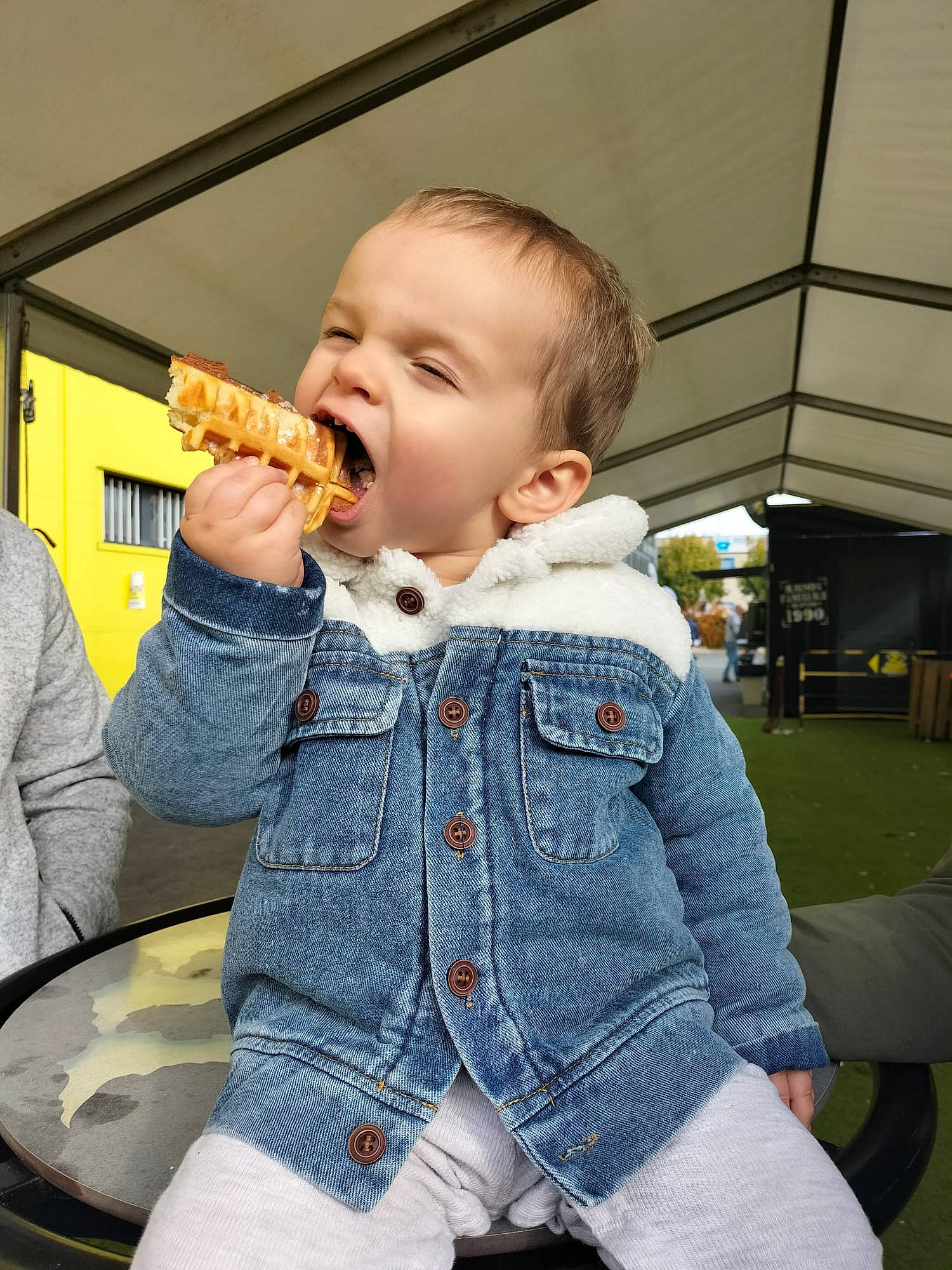 Tylio a rejoint le concours — aidez-le/la à gagner de superbes lots ! baby, baby_toddler_clothing, biting, chair, child, cuisine, denim, fast_food, finger, finger_food, food, food_craving, fun, ingredient, junk_food, nose, person, sitting, sleeve, standing