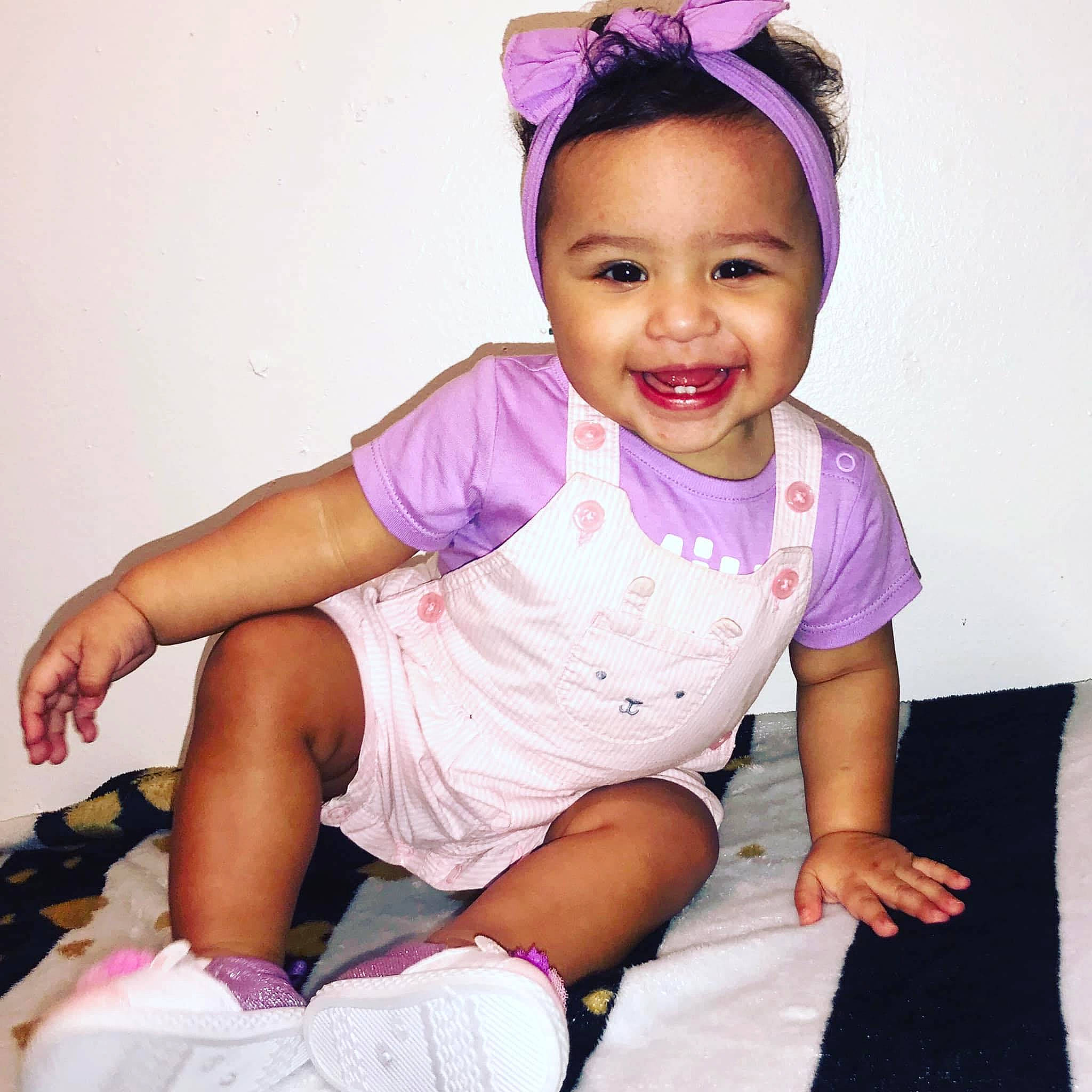 Melani is registered to the contest to win money with this photo: baby_toddler_clothing, cheek, cool, face, finger, happy, head, headband, joy, leg, magenta, neck, person, pink, product, purple, skin, sleeve, smile, thigh