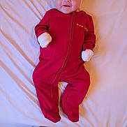 Milena participe au concours pour gagner de l'argent avec cette photo : child, baby, infant, onesie, headband, mittens, bed, bedsheet, smile, face, eyes, pajamas, red_clothing, pink_headband, lying_down, white_sheet, soft_fabric, cozy, newborn, portrait