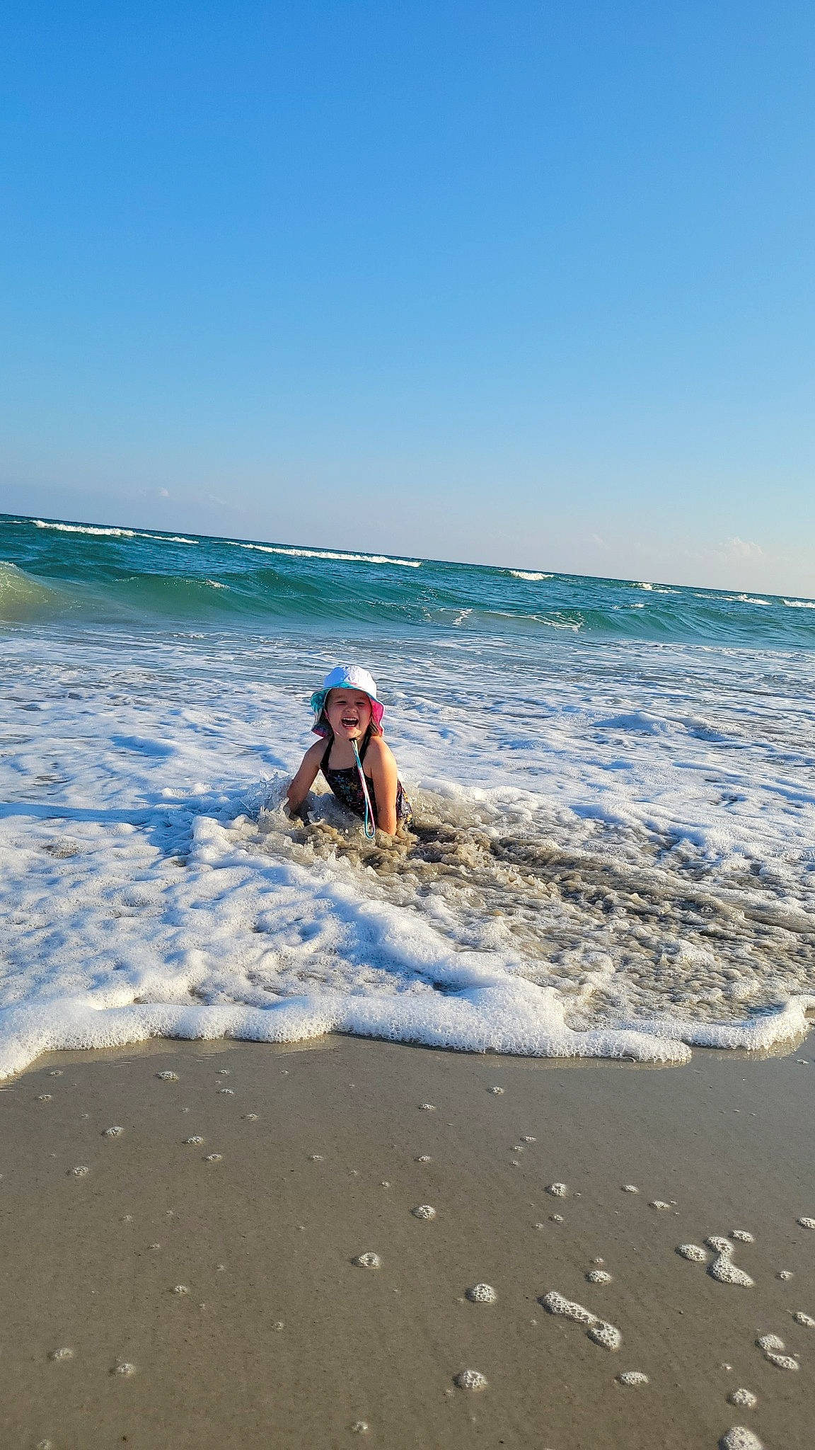 Emery is registered to the contest to win money with this photo: beach, cloud, coastal_and_oceanic_landforms, electric_blue, fun, happy, headwear, holiday, horizon, landscape, leisure, people_on_beach, person, recreation, sand, sky, travel, tropics, water, wave