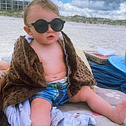 Avery is registered to the contest to win money with this photo: toddler, child, beach, sunglasses, blanket, sand, cloudy_sky, shorts, summer, outdoor, vacation, relaxing, cute, baby, sun_protection, dunes, blue_sky, casual, portrait, sitting