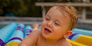 Avery joined the competition — help win amazing prizes! toddler, child, water, pool, inflatable, yellow, summer, happy, playful, outdoor, wet, splash, skin, face, hands, float, relaxation, daylight, nature, fun
